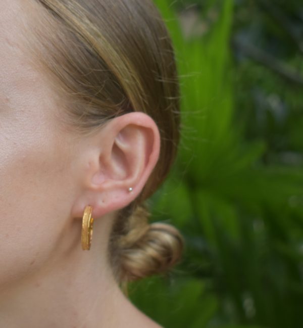 large gold textured hoops worn